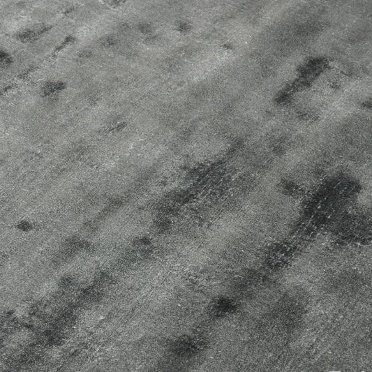 Textured grey rug surface with dark patches
