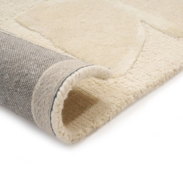 Close-up of a beige and gray textured rug corner on a white background