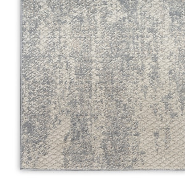 Textured grey and white patterned rug on a plain background