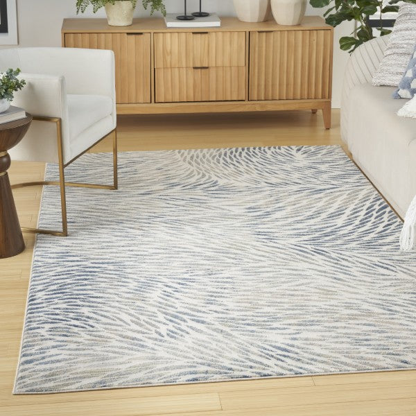 Living room with a patterned rug, wooden sideboard, and white chairs.