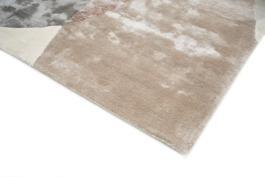Close-up of a textured rug with neutral colors on a white background