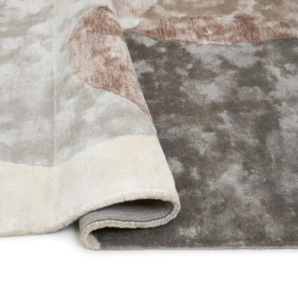 Close-up of a textured rug with a gradient of colors on a white background