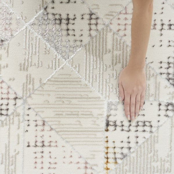 Close-up of a textured rug with geometric pattern and a hand touching it