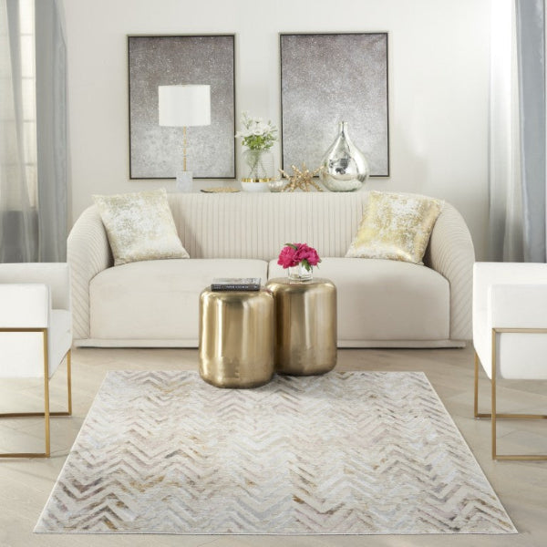 Modern living room with a beige sofa, gold coffee tables, and decorative elements.