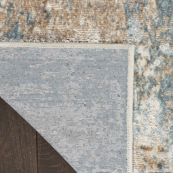 Close-up of a textured rug with a neutral color palette on a wooden floor.