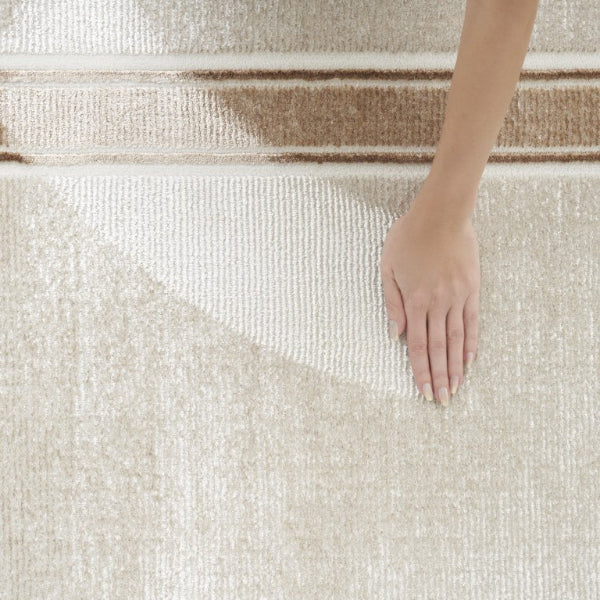 Close-up of a hand touching a textured beige carpet