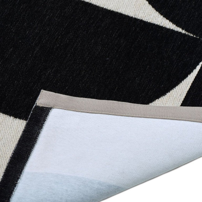 Close-up of a black and white patterned rug with geometric shapes.