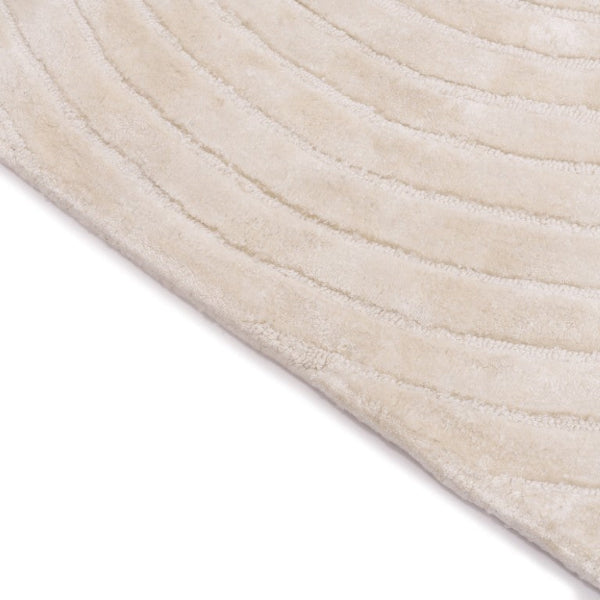 Close-up of a textured beige rug corner on a white background