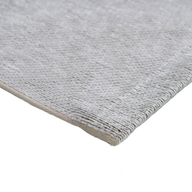 Close-up of a gray textured rug corner on a white background