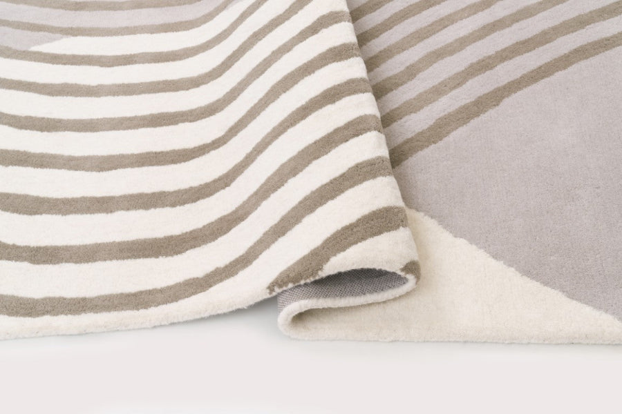 Close-up of striped fabric with beige and white stripes on a light gray background