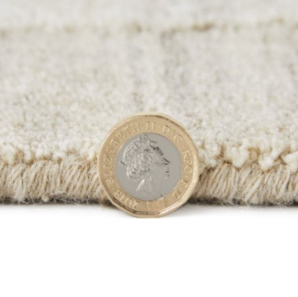 Close-up of Concept Looms Dune Rug texture and thickness shown with UK coin next to edge