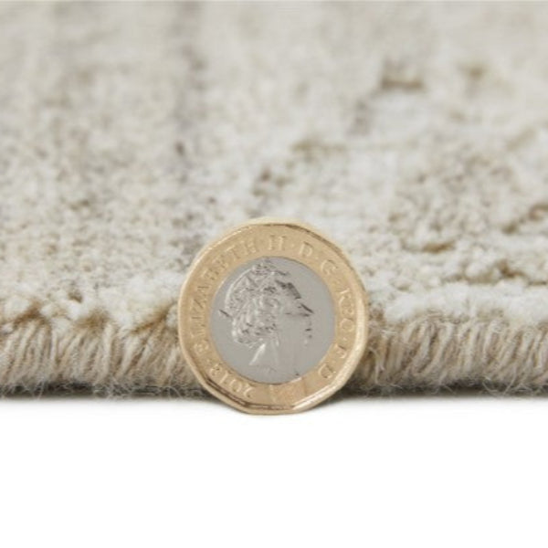 Close-up of Concept Looms Dune Rug showing texture and pile height with a British pound coin for scale