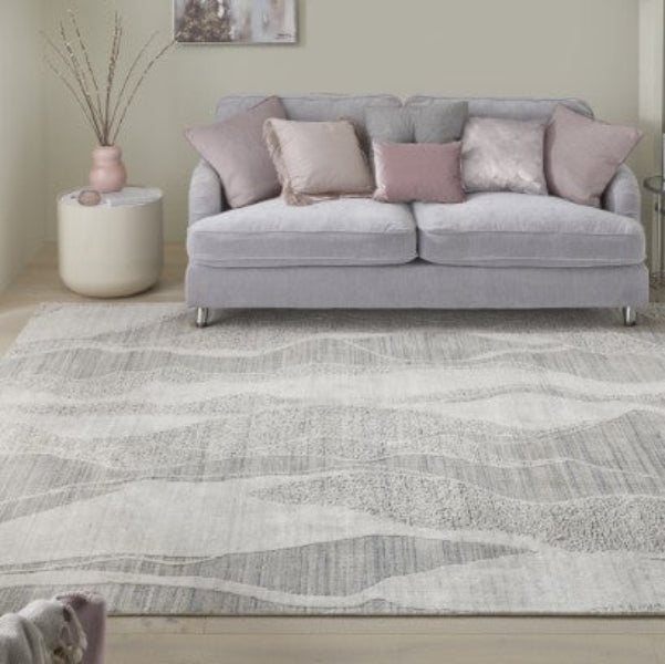 Luxury living room featuring Concept Looms Dune Rug with soft, wavy patterns under a grey sofa