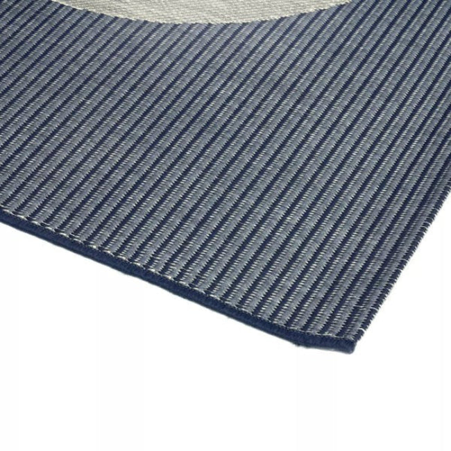Close-up of a blue and gray striped rug corner on a white background