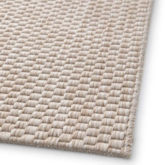 Close-up of a textured beige rug on a white background