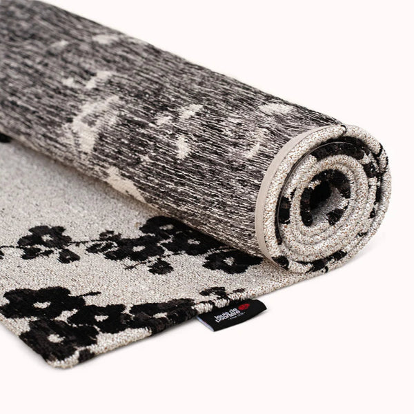 Roll of patterned carpet with a visible brand logo on a white background