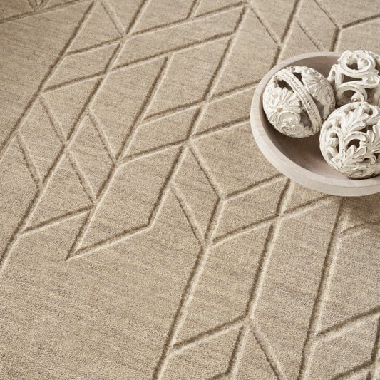 Beige textured Nourison Alessia rug featuring geometric patterns with decorative white carved spheres