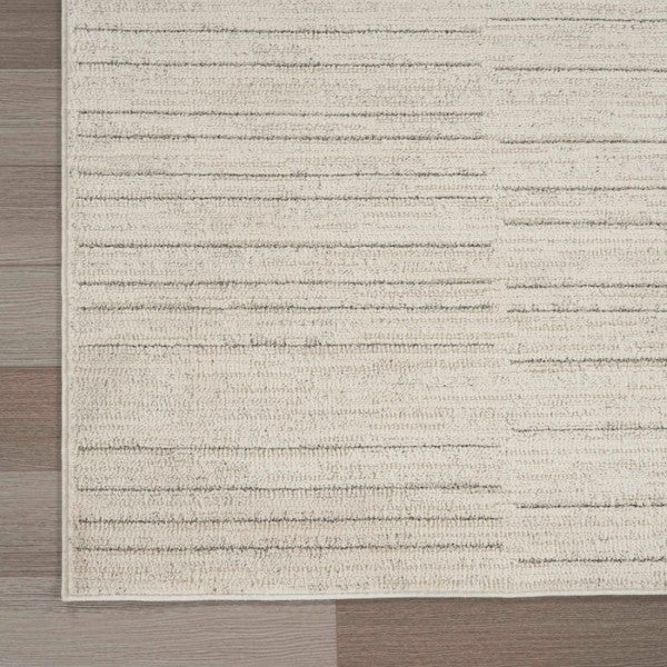 Luxury beige and grey textured Nourison Andes Rug Collection on wooden floor corner