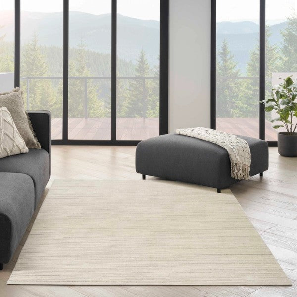 Nourison Andes Rug Collection luxury rug in neutral tone placed in modern living room with grey sofa and ottoman