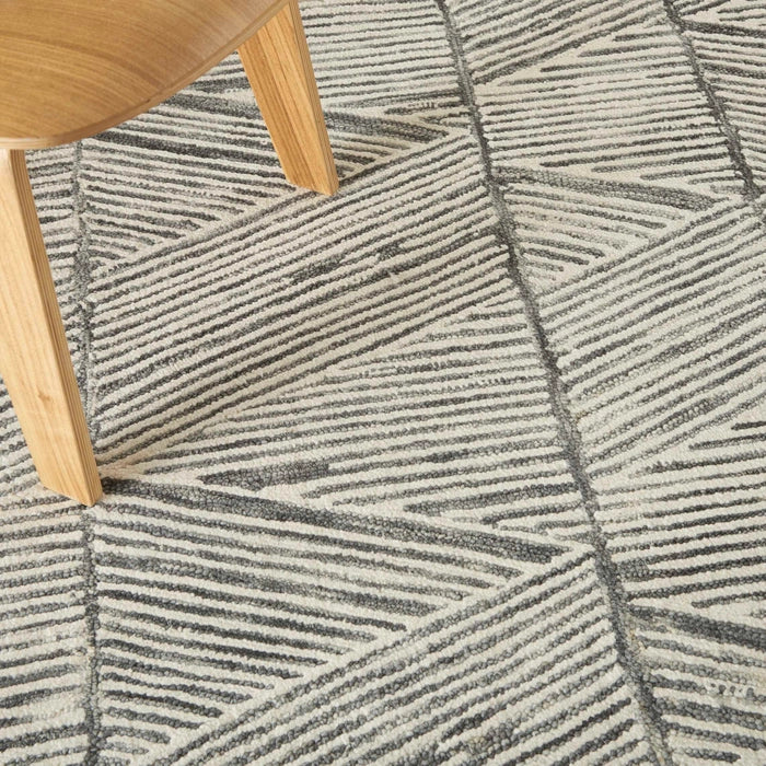 Close-up of Nourison Colorado Rug Geometric Design in grey tones under wooden chair leg