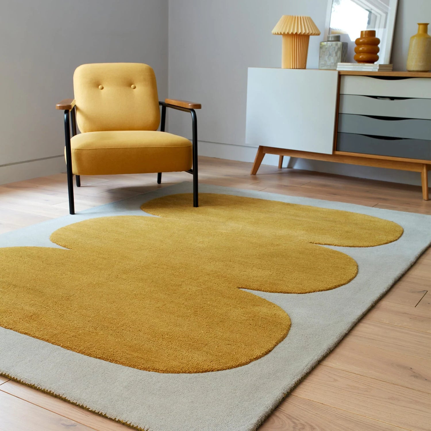 Modern living room featuring a yellow armchair and a stylish Asiatic London rugs carpet with bold yellow and grey design