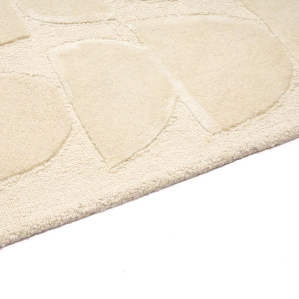 Close-up of a textured beige rug with circular patterns on a white background