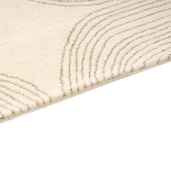 Close-up of a textured beige rug with wavy pattern on a white background