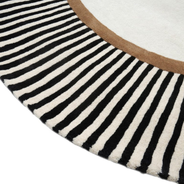 Close-up of a black and white striped rug with a brown border on a white background