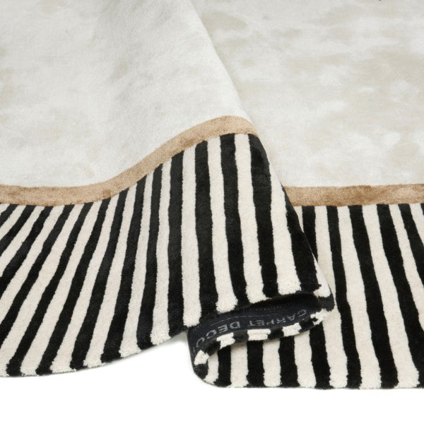 Black and white striped blanket with beige border on a white background