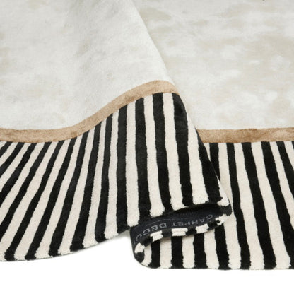 Black and white striped blanket with beige border on a white background