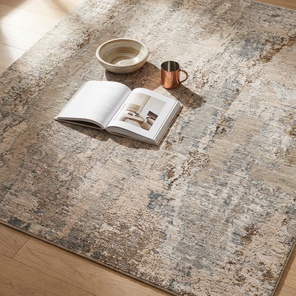 Open book, copper mug, and ceramic bowl on a textured stone-like floor.