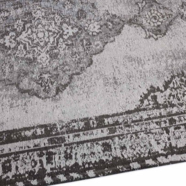 Close-up of a textured grey and black area rug with intricate patterns.