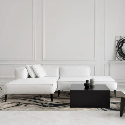 Modern living room with white sofa, black coffee table, and abstract art on wall.