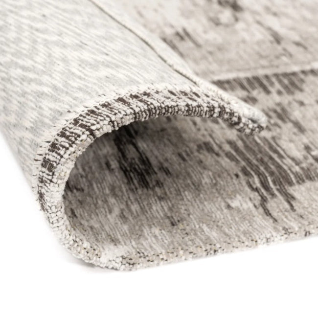 Roll of gray and white patterned rug on a white background