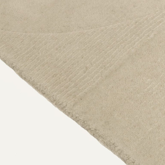 Close-up of a textured beige fabric with a subtle pattern on a white background