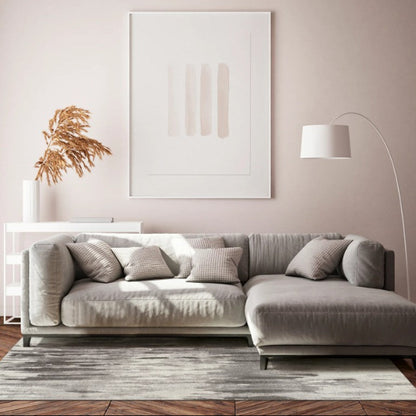 Modern living room with a gray sectional sofa, abstract art, and a lamp.