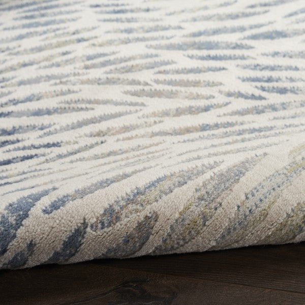 Textured blue and beige rug on a wooden floor