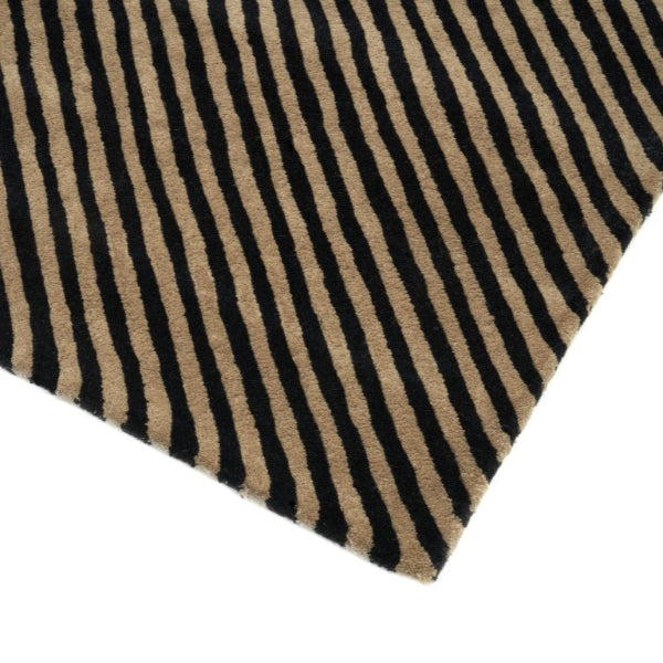 Close-up of a striped rug with black and beige lines on a white background