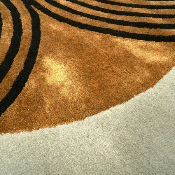 Close-up of a rug with concentric circular patterns in brown, black, and beige.