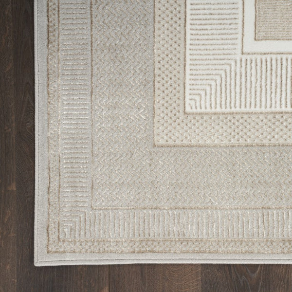 Close-up of a textured beige rug with geometric patterns on a wooden floor.