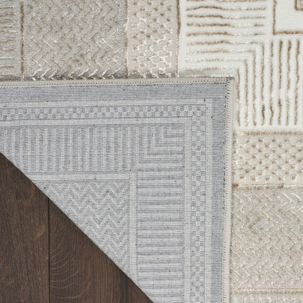 Close-up of a textured rug with geometric patterns on a wooden floor.
