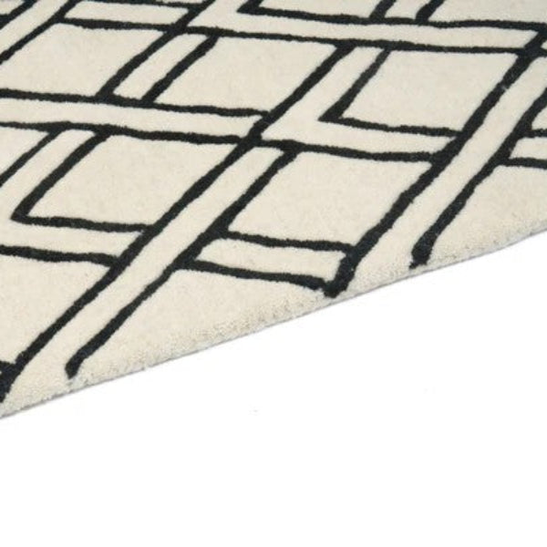 Close-up of a geometric patterned rug with black lines on a white background