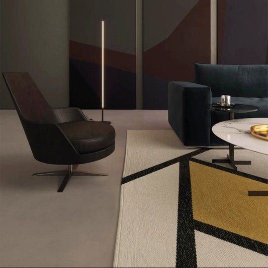 Modern living room with a black armchair, floor lamp, and coffee table.