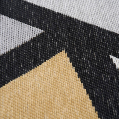 Close-up of a geometric patterned fabric with triangles in black, beige, and grey.