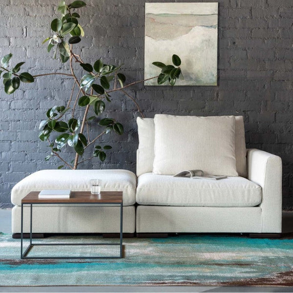 Modern living room with a white sofa, coffee table, and decorative rug.