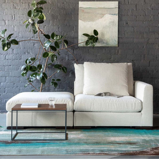 Modern living room with a white sofa, coffee table, and decorative rug.