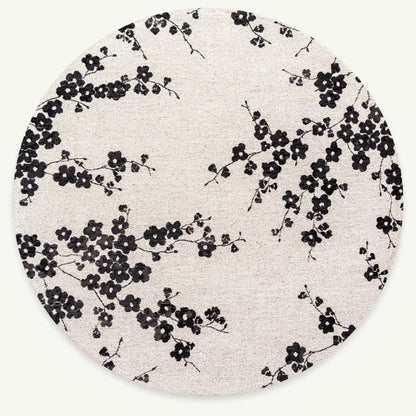Round rug with black floral pattern on a white background