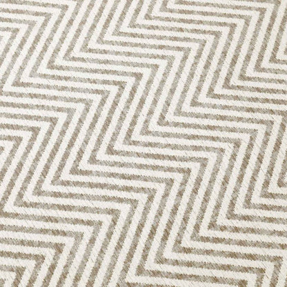 Patterned fabric with zigzag design in beige and brown tones.