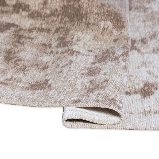 Close-up of a textured beige and brown rug with a white border.