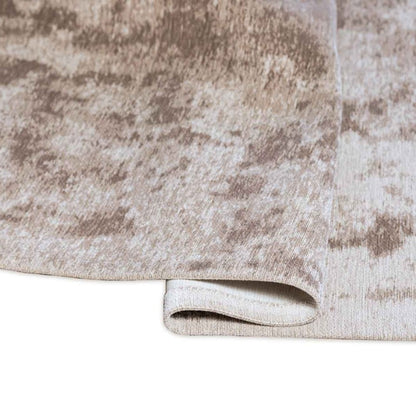 Close-up of a textured beige and brown rug with a white border.